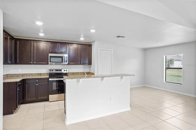 a kitchen with stainless steel appliances granite countertop a stove top oven a sink and dishwasher