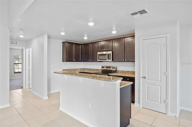 a kitchen with stainless steel appliances granite countertop a refrigerator and a stove