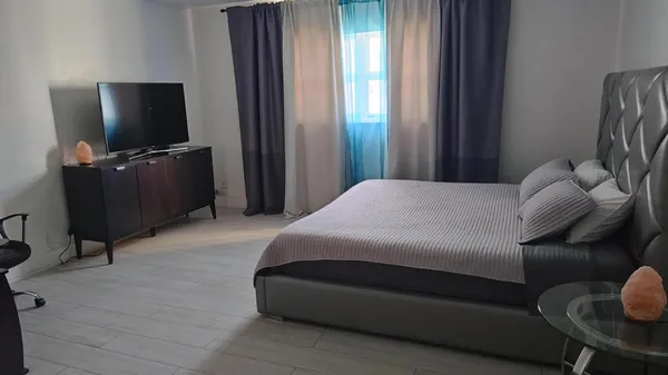 a bedroom with a bed and a flat screen tv