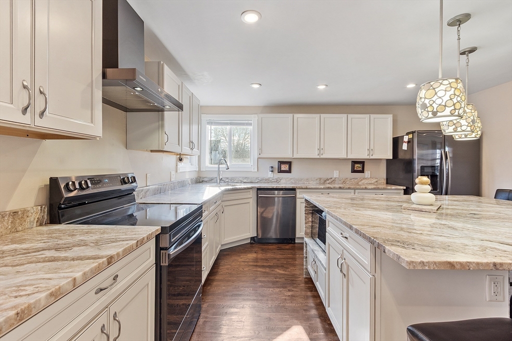 459 High Street Clinton, MA 01510 - Photo 12 of 35 a kitchen with kitchen island granite countertop a sink a counter top space appliances and cabinets
