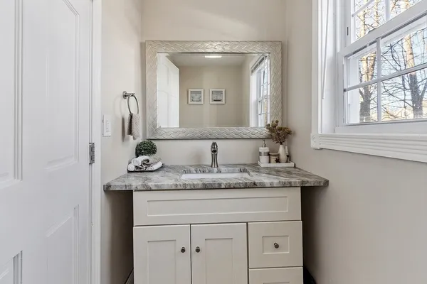 a bathroom with a granite countertop sink and a mirror