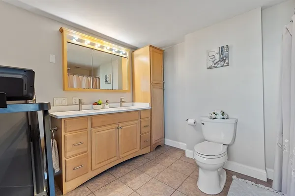 a spacious bathroom with a toilet sink and mirror