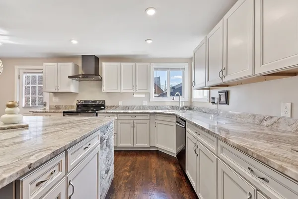 a kitchen with kitchen island granite countertop a sink cabinets stainless steel appliances and a counter space
