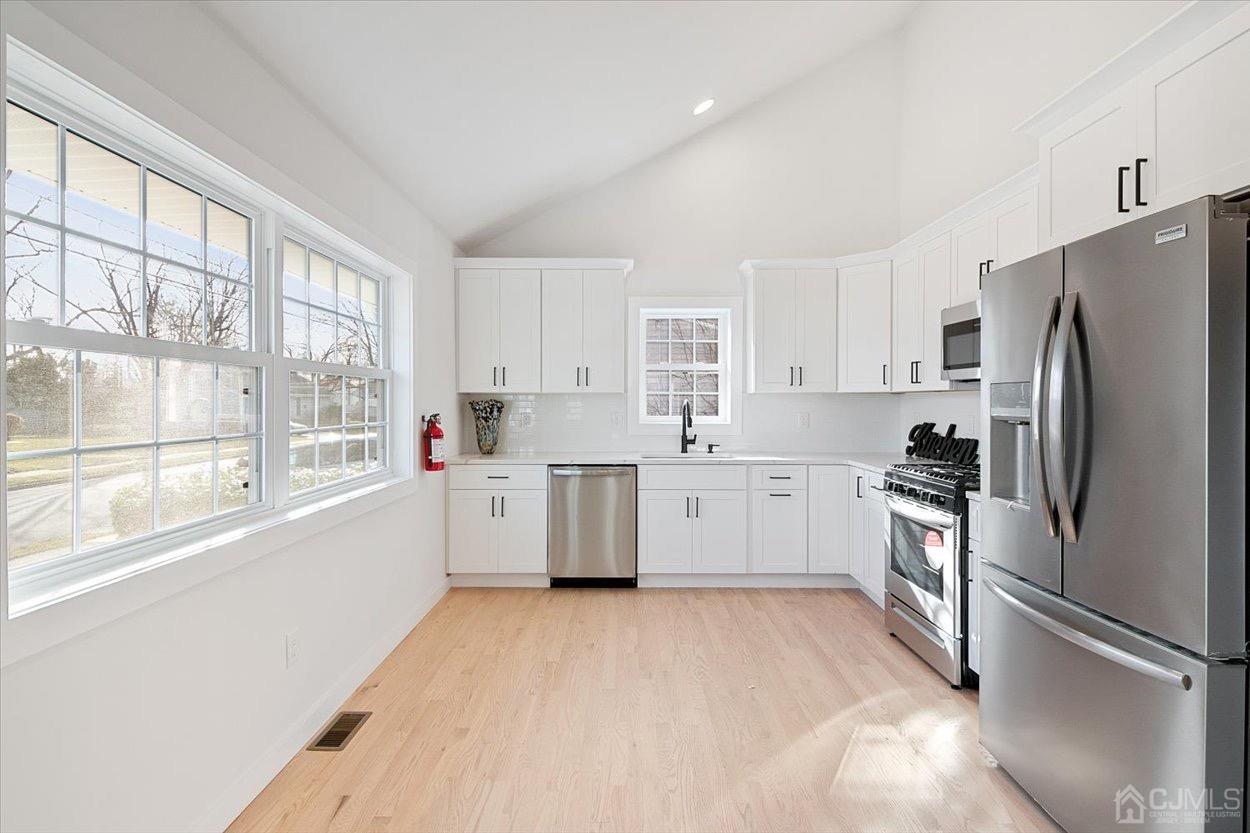 47 Eardley Road Edison, NJ 08817 - Photo 11 of 29 a kitchen with a refrigerator a sink and white cabinets