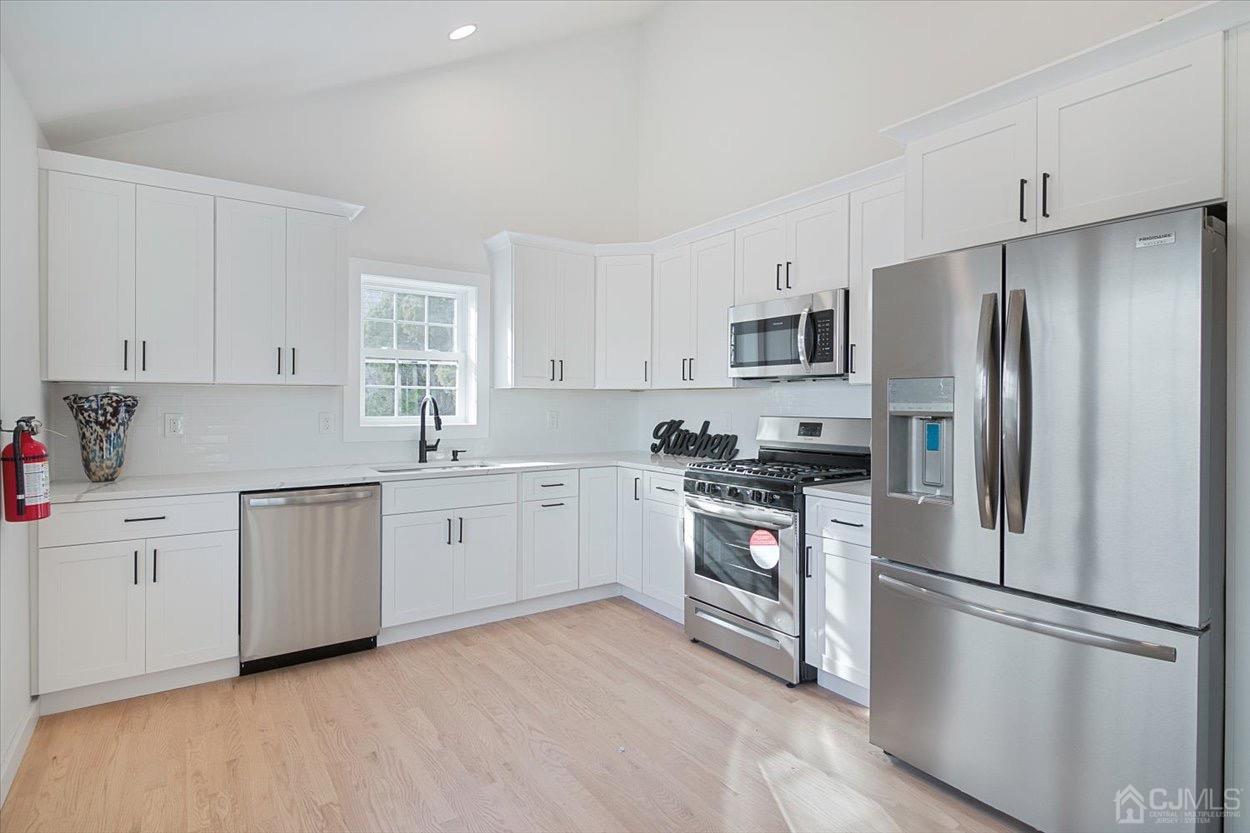 47 Eardley Road Edison, NJ 08817 - Photo 12 of 29 a kitchen with a refrigerator stove top oven and cabinets