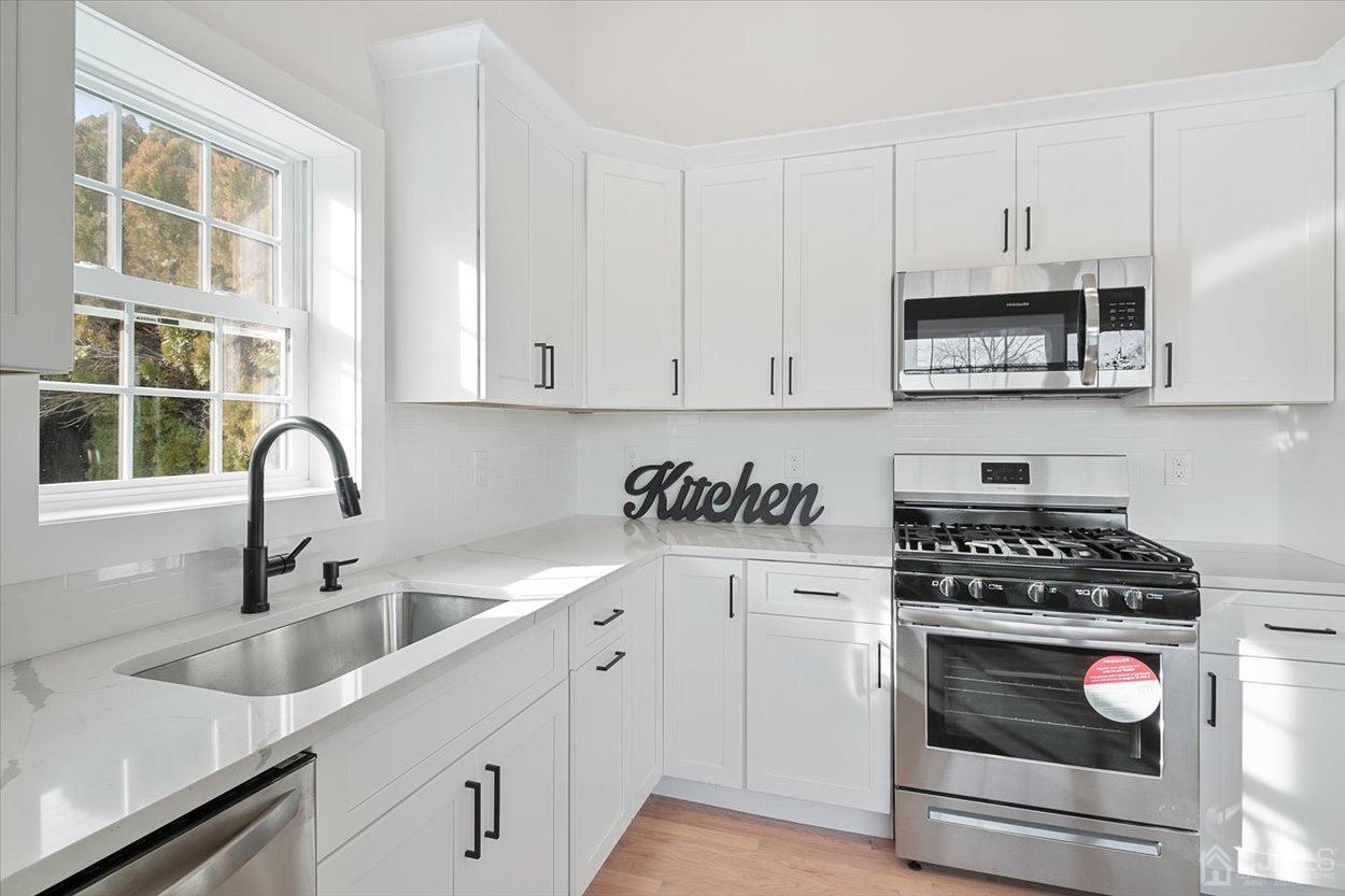 47 Eardley Road Edison, NJ 08817 - Photo 10 of 29 a kitchen with stainless steel appliances granite countertop a sink stove and cabinets