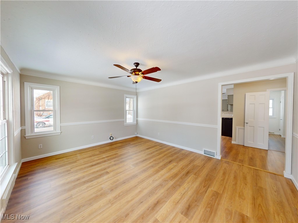 1343 Irene Road Lyndhurst, OH 44124 - Photo 3 of 32 Spare room with crown molding, light hardwood / wood-style flooring, and ceiling fan