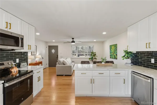 a kitchen with white cabinets and appliances