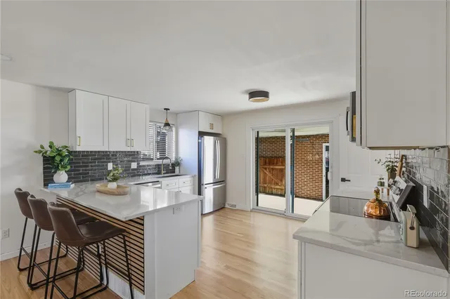 a kitchen with a table chairs refrigerator and cabinets
