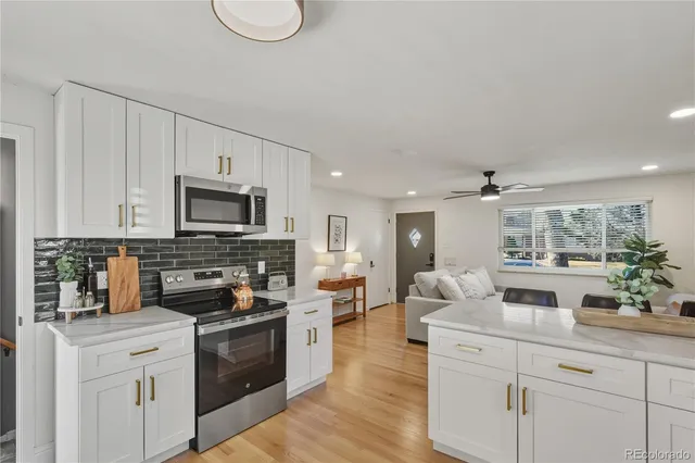 a kitchen with white cabinets a sink and appliances