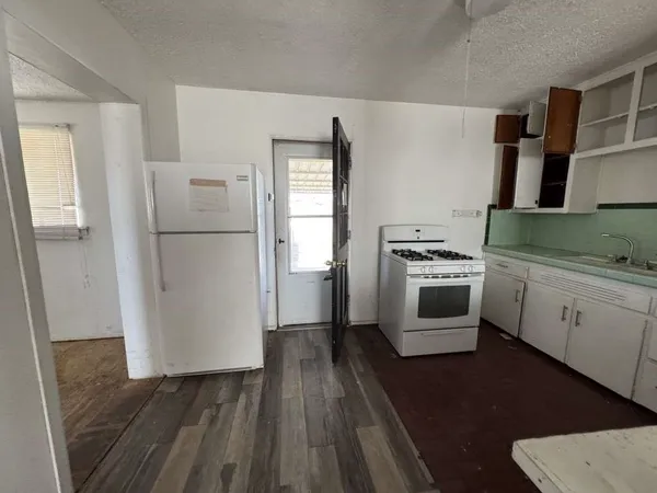 a kitchen with white cabinets and white appliances