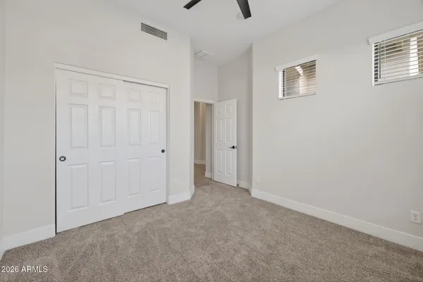 a view of a big room with windows and chandelier fan