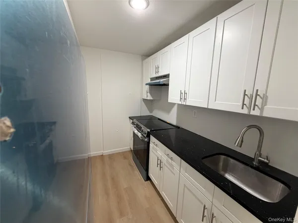 a kitchen with granite countertop a sink stainless steel appliances and cabinets