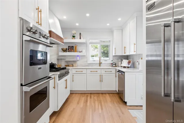 a kitchen with a sink stainless steel appliances and white cabinets