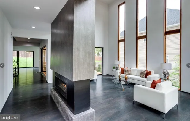 a living room with fireplace furniture and a large window