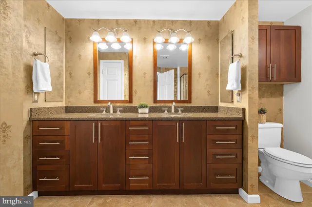a bathroom with a sink a toilet and a large mirror