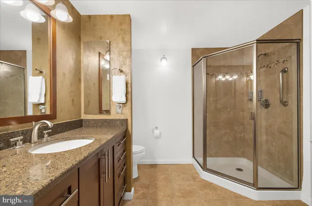 a bathroom with a granite countertop shower sink and mirror