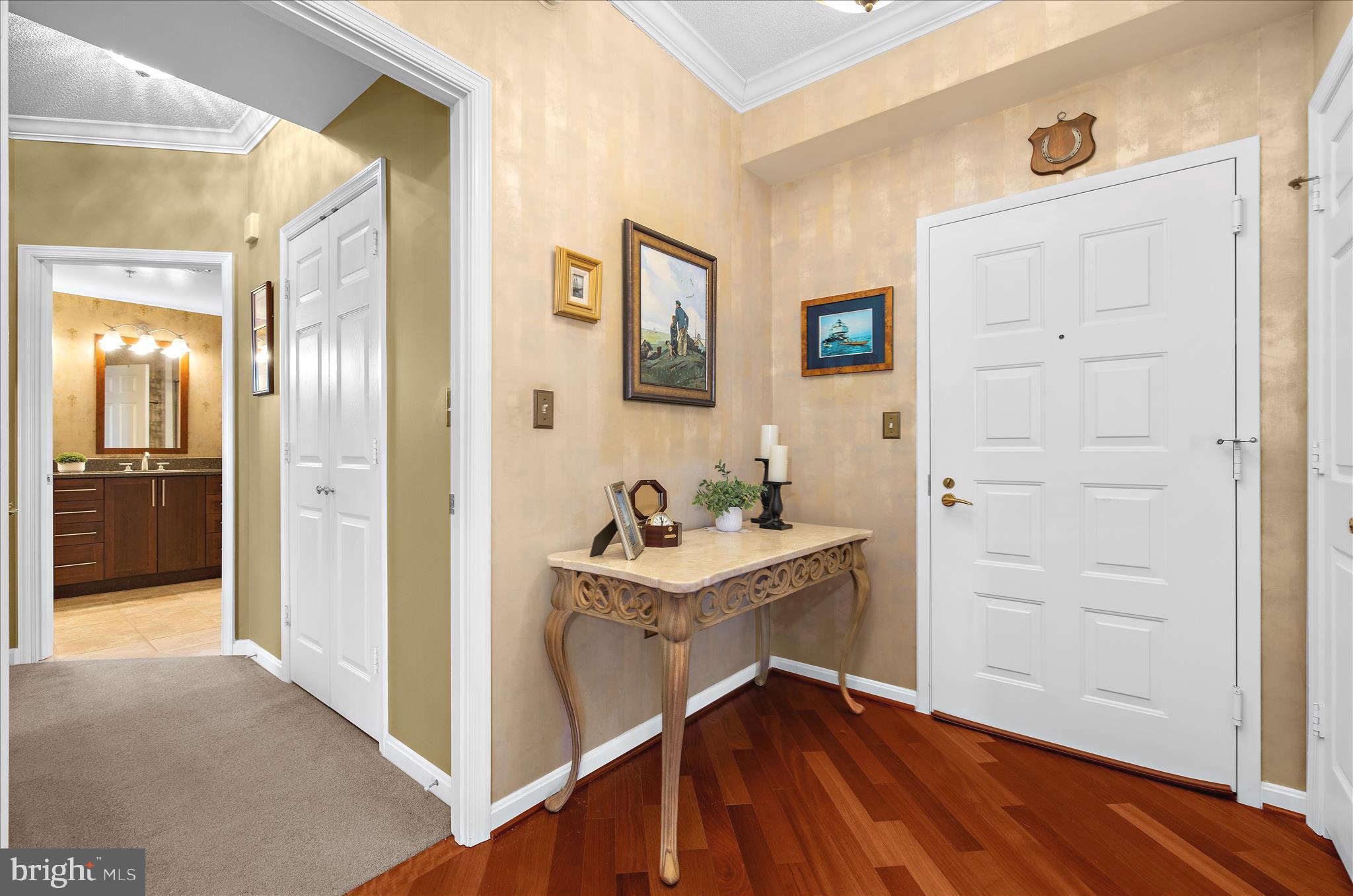 940 Astern Way, Unit 607 Annapolis, MD 21401 - Photo 2 of 45 a view of a hallway to a livingroom with wooden floor a fireplace and windows