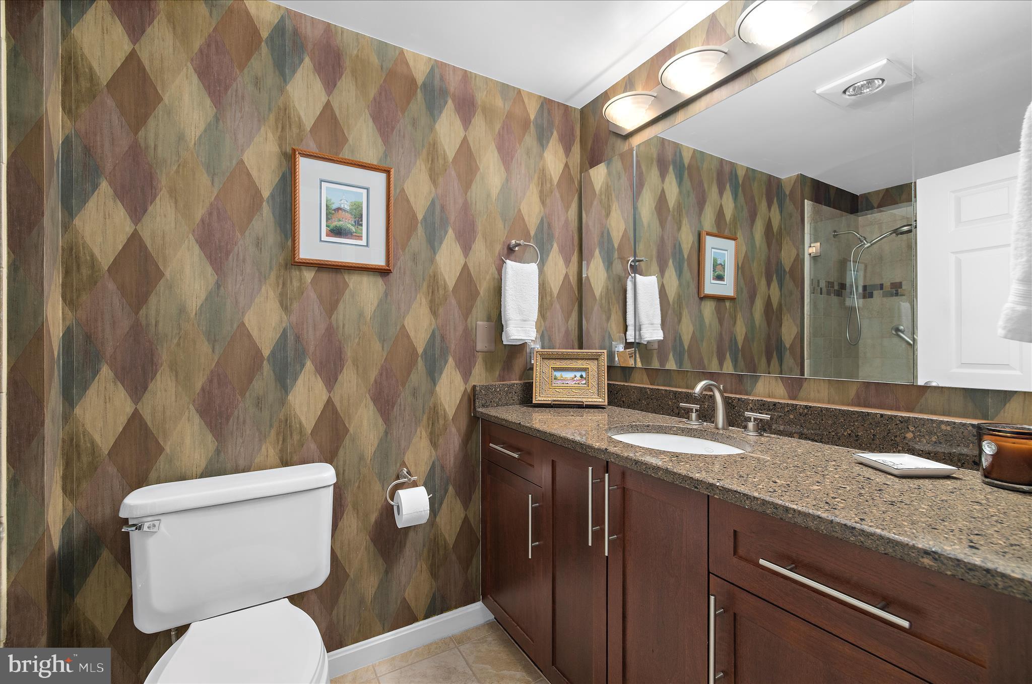 940 Astern Way, Unit 607 Annapolis, MD 21401 - Photo 23 of 45 a bathroom with a granite countertop toilet sink and mirror