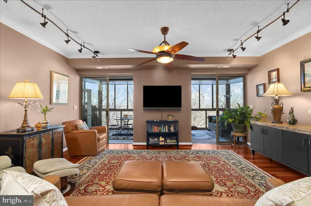 a living room with furniture a flat screen tv and a chandelier