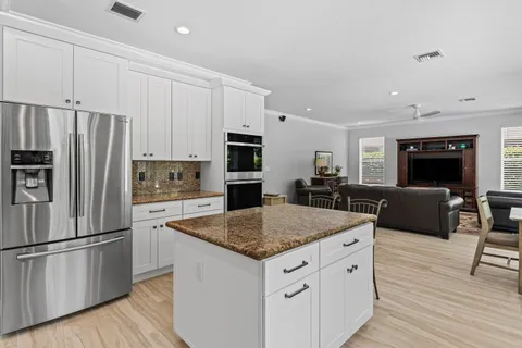 a kitchen with stainless steel appliances granite countertop a refrigerator stove microwave and sink