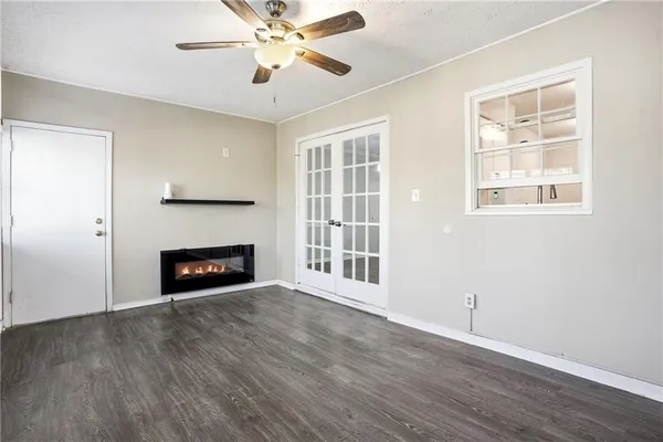 a view of an empty room with a window and wooden floor
