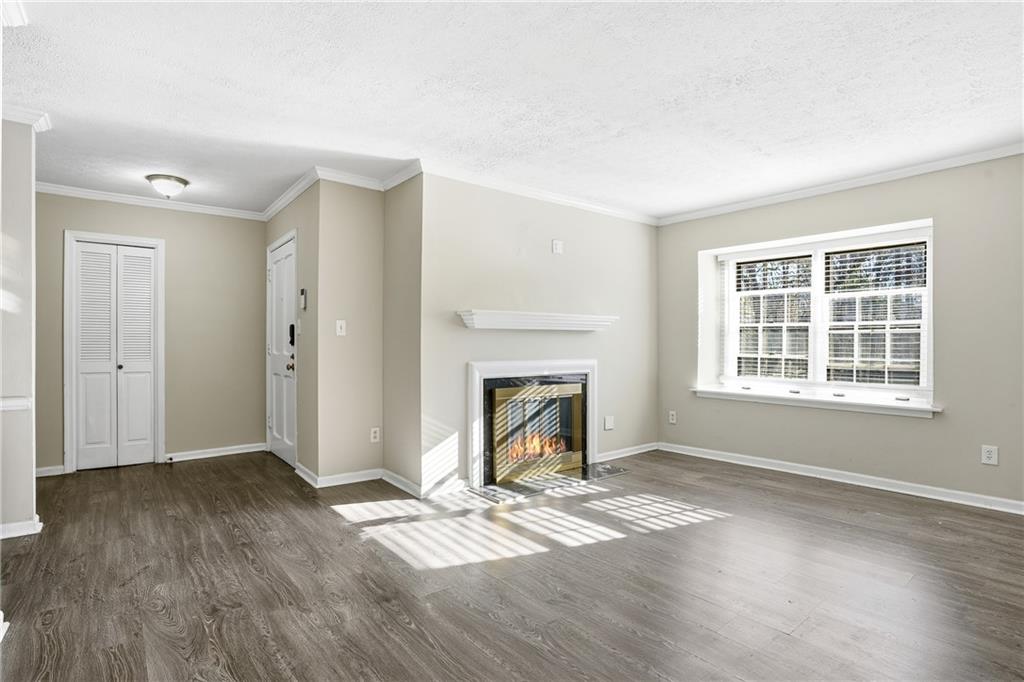 151 Elysian Way Northwest Atlanta, GA 30327 - Photo 3 of 31 a view of an empty room with wooden floor fireplace and a window