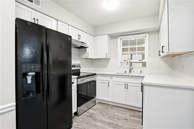 a kitchen with a sink stainless steel appliances and refrigerator