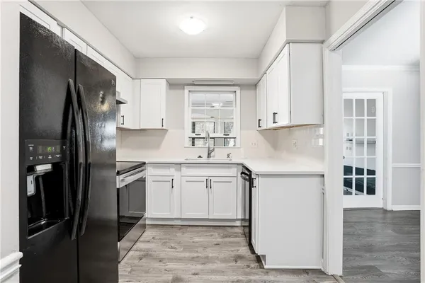 a kitchen with a refrigerator sink and cabinets