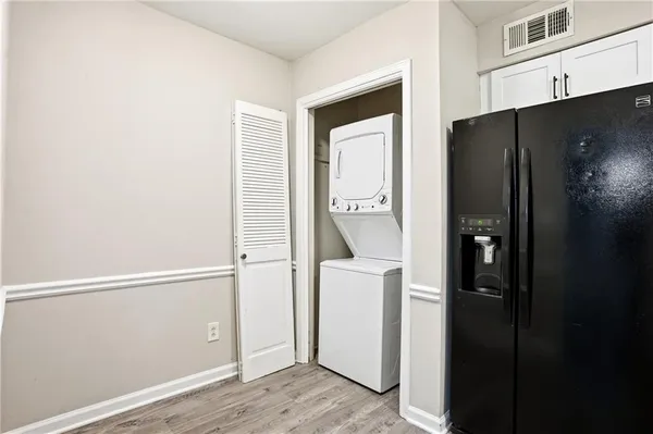 a view of an empty room with wooden floor fireplace and a window