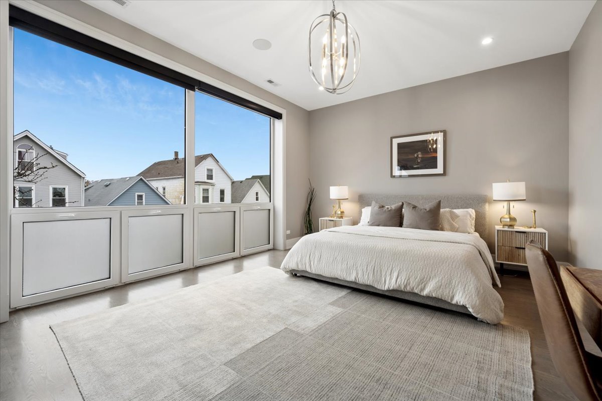 3518 West Wolfram Street, Unit 2 Chicago, IL 60618 - Photo 14 of 34 a spacious bedroom with a bed chandelier and a window