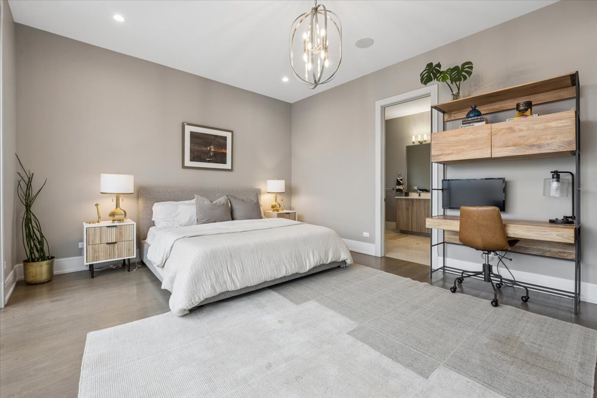 3518 West Wolfram Street, Unit 2 Chicago, IL 60618 - Photo 16 of 34 a bedroom with a bed and a chandelier