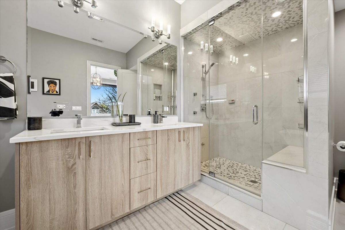 3518 West Wolfram Street, Unit 2 Chicago, IL 60618 - Photo 18 of 34 a bathroom with a double vanity sink mirror and shower