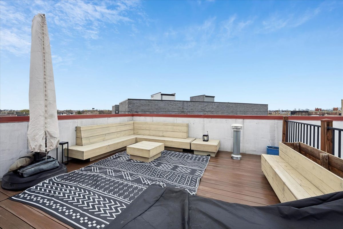 3518 West Wolfram Street, Unit 2 Chicago, IL 60618 - Photo 32 of 34 a view of a balcony with wooden floor and chairs