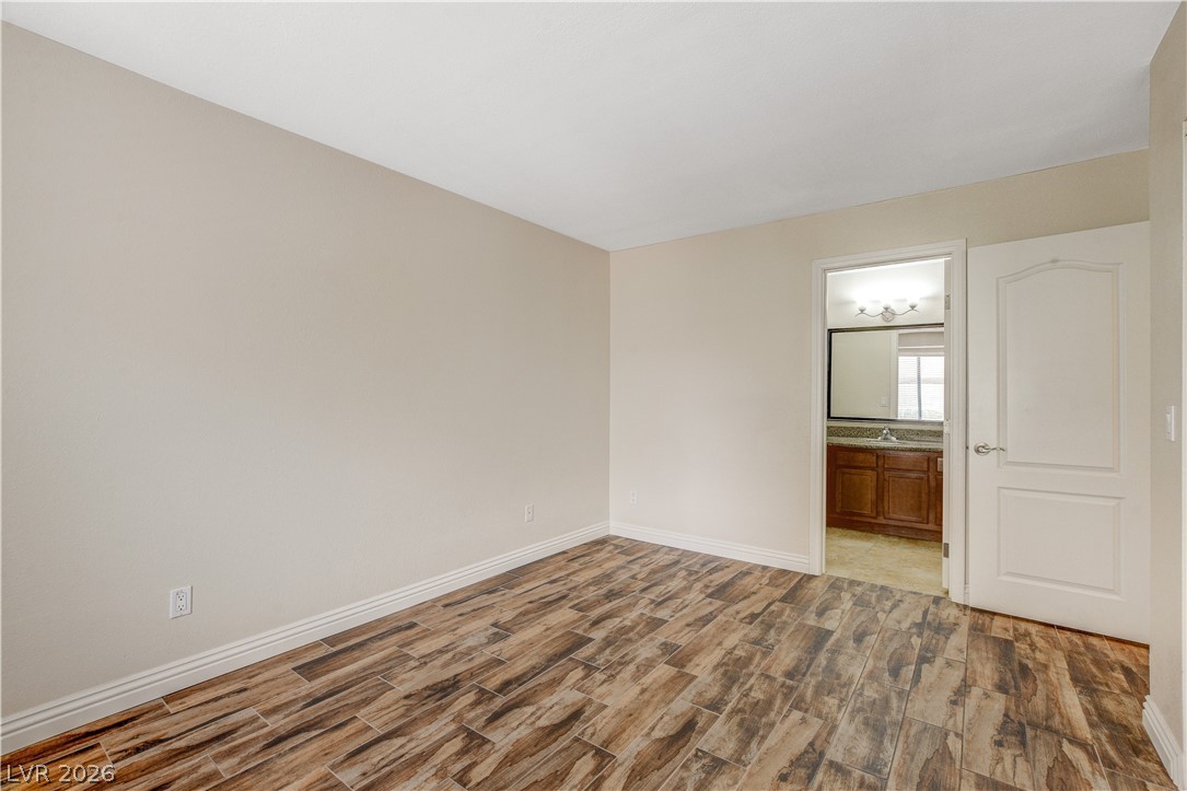 7200 West Pirates Cove Road, Unit 1026 Las Vegas, NV 89145 - Photo 25 of 35 This bright room features durable wood-look tile flooring and provides direct access to an attached private bath.