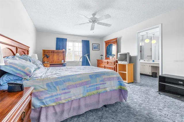 a bedroom with a bed dresser and a flat tv screen