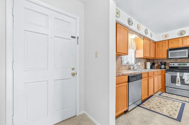 a kitchen with stainless steel appliances granite countertop a sink a stove and white cabinets