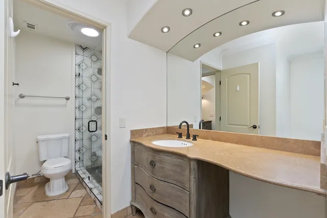 a bathroom with a sink a toilet and shower