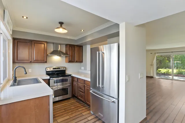 a kitchen with granite countertop a refrigerator stove top oven and sink