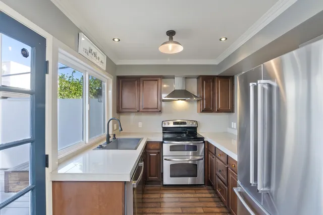 a kitchen with stainless steel appliances granite countertop a sink stove and refrigerator