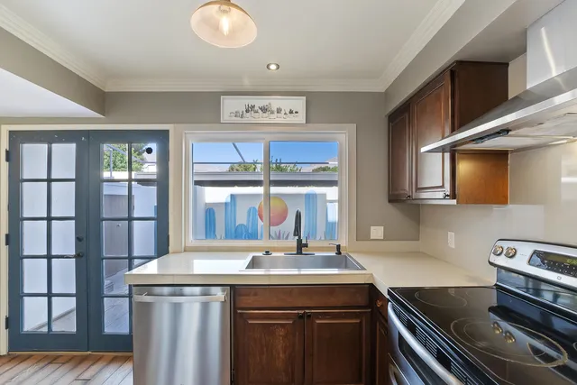 a kitchen with stainless steel appliances granite countertop a sink stove and cabinets