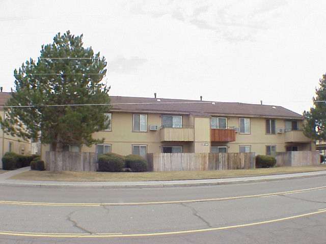 a view of a white building among the street and trees