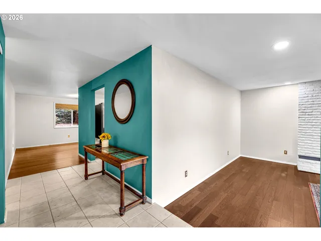 a living room with furniture a rug potted plant and a window