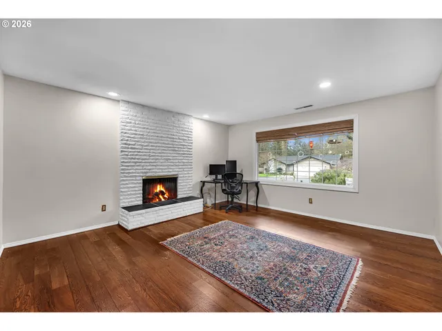 a view of an empty room with a fireplace and window