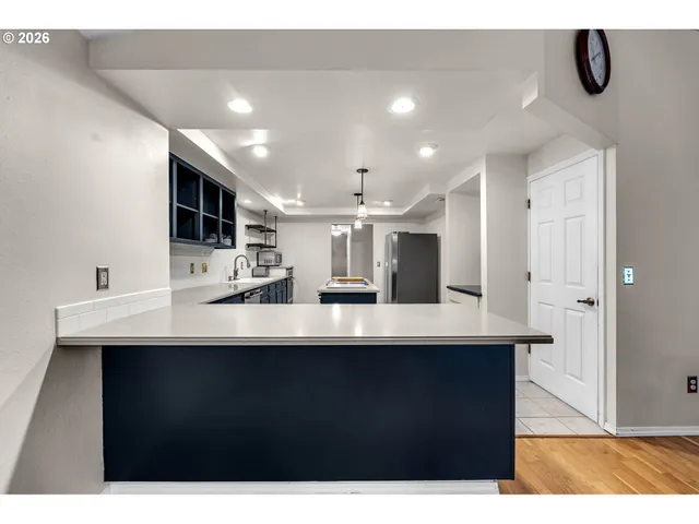 a kitchen with kitchen island stainless steel appliances a sink and a refrigerator
