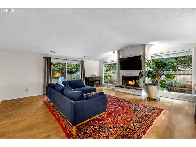 a living room with furniture a flat screen tv and a fireplace