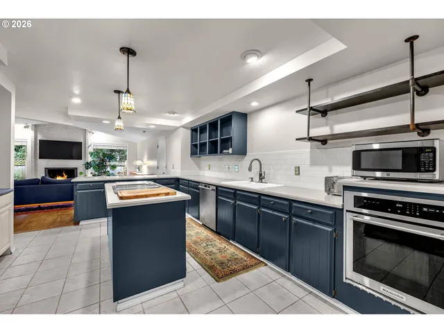 a kitchen with stainless steel appliances kitchen island granite countertop a stove top oven a sink and a microwave