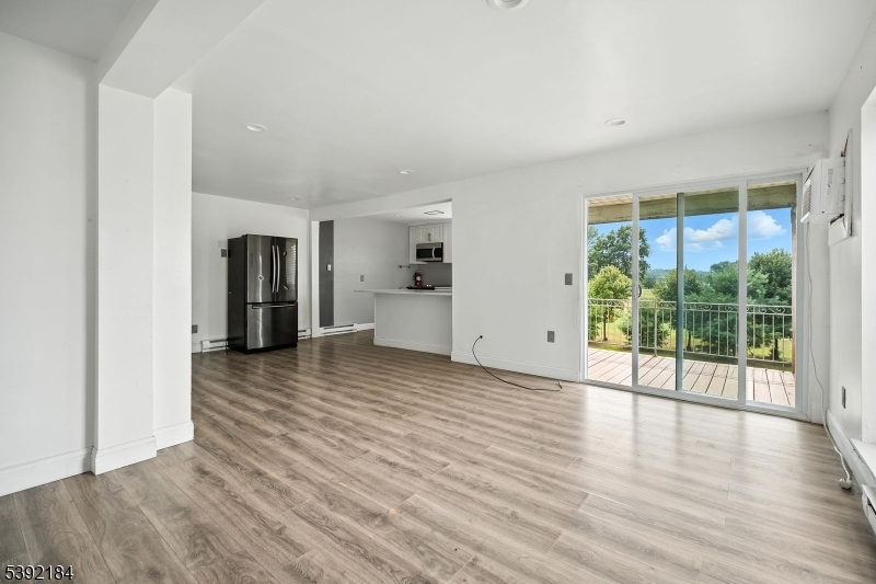 a view of empty room with wooden floor and floor to ceiling window