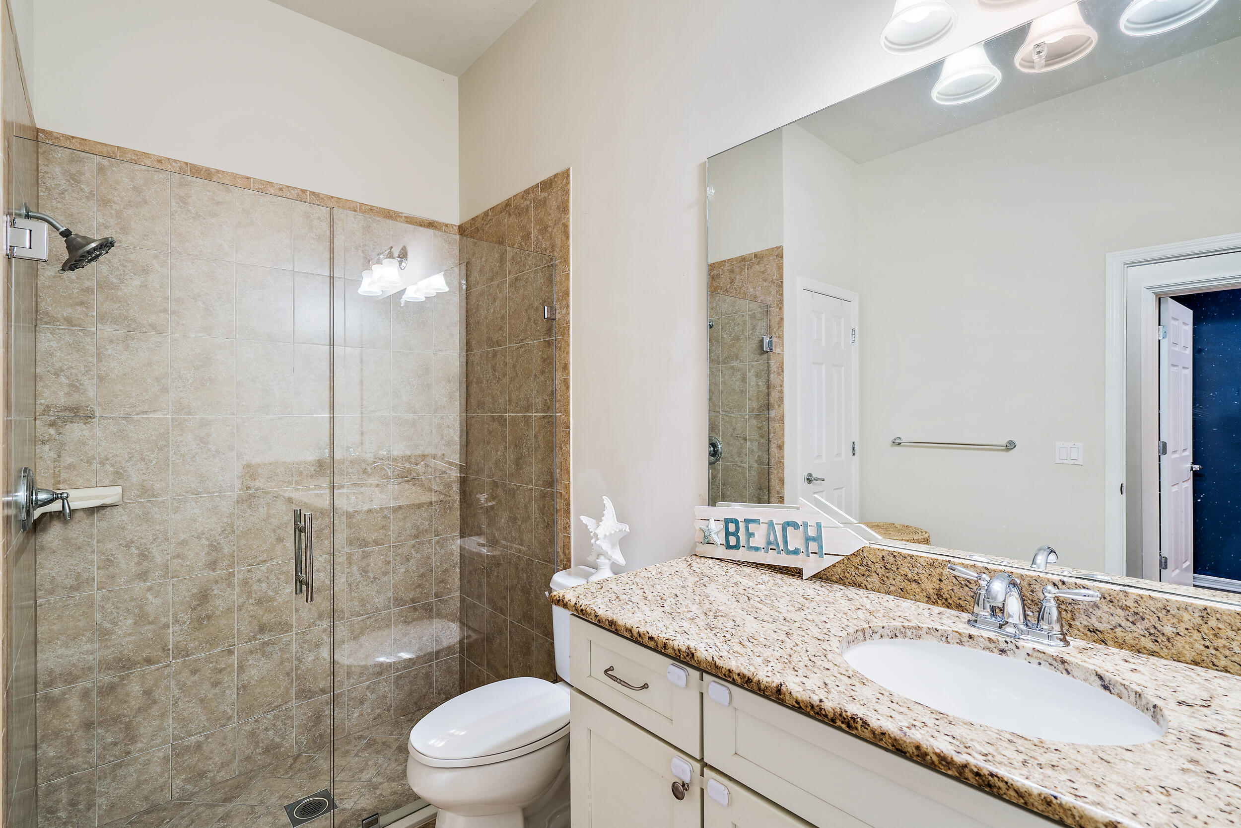 2704 Sunbury Drive Jupiter, FL 33458 - Photo 29 of 50 a bathroom with a granite countertop sink a toilet and shower