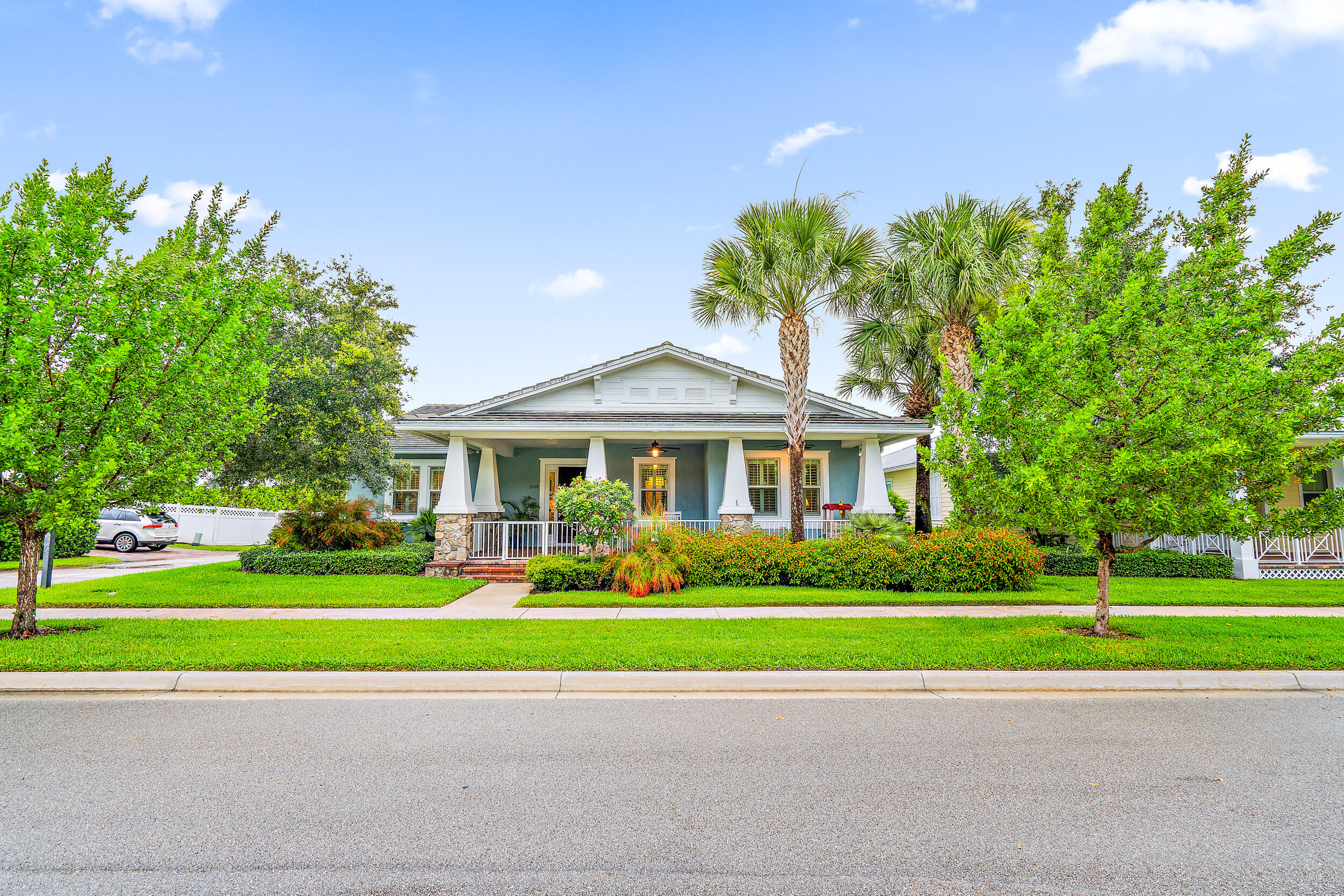 2704 Sunbury Drive Jupiter, FL 33458 - Photo 48 of 50 a front view of a house with a yard and trees